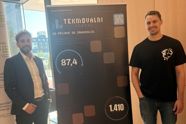 Toni and Jakob either side of our Tekmovalni portal and Everyframe banner at Dan inovativnosti.